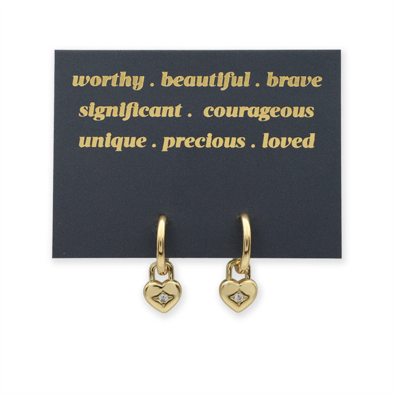 Gold heart-shaped earrings on a black card with gold text.