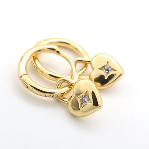 Gold ring with heart-shaped pendants on a white background