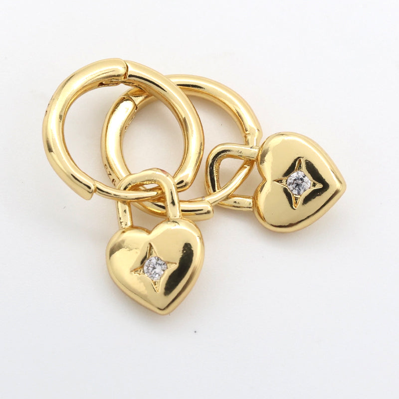 Gold heart-shaped charm with diamonds on a white background