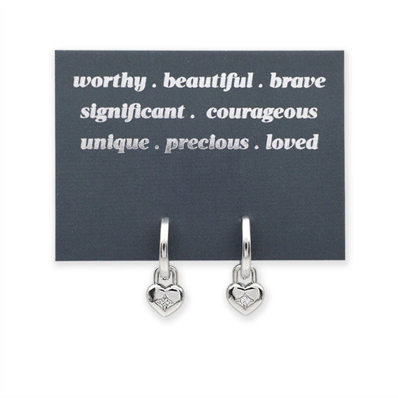 Silver heart-shaped earrings on a card with motivational phrases