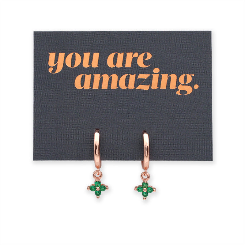 Rose gold earrings with green gemstones on a card with 'you are amazing' text.