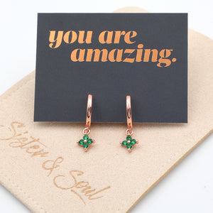 Rose gold earrings with green gemstones on a 'you are amazing' card.