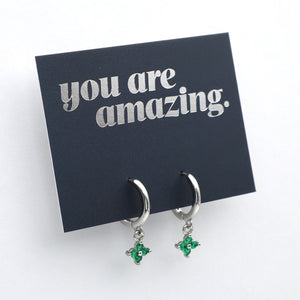 Silver earrings with green gemstones on a card that says 'you are amazing' on a white background