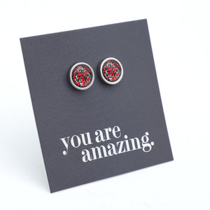 Round earrings with red and silver design on a 'you are amazing' card