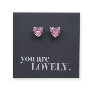 Heart-shaped pink earrings on a card with 'you are LOVELY.' text