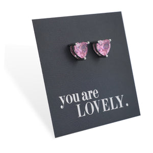 Heart-shaped pink earrings on a black card with 'you are lovely' text