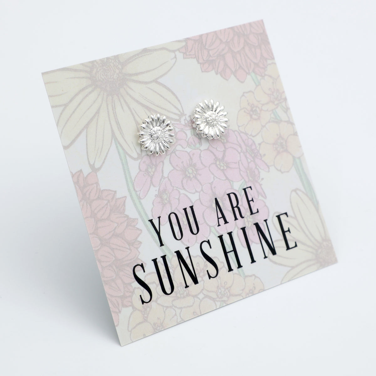 Silver earrings on a floral card with 'You are Sunshine' text