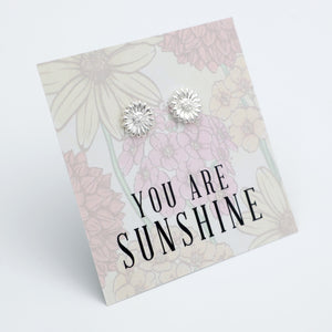 Silver earrings on a floral card with 'You are Sunshine' text