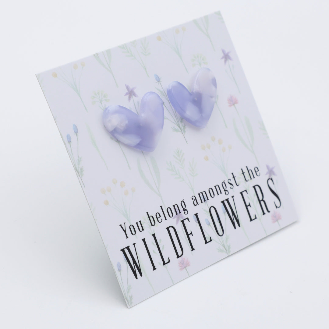 Heart-shaped earrings on a card with 'You belong amongst the wildflowers.' text