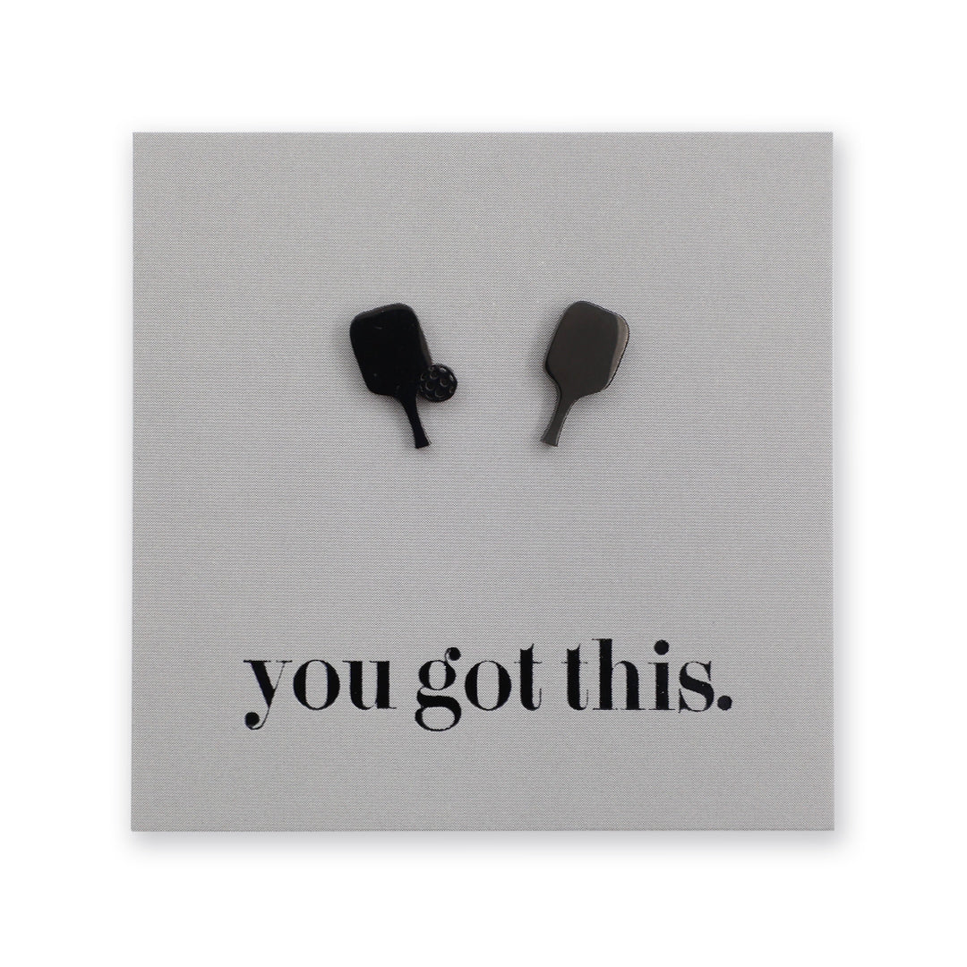 A square gray plaque or sign with two small pickleball paddle-shaped stud mounted near the top and the phrase 'you got this.' printed in black lowercase serif text near the bottom, shown on a white background.