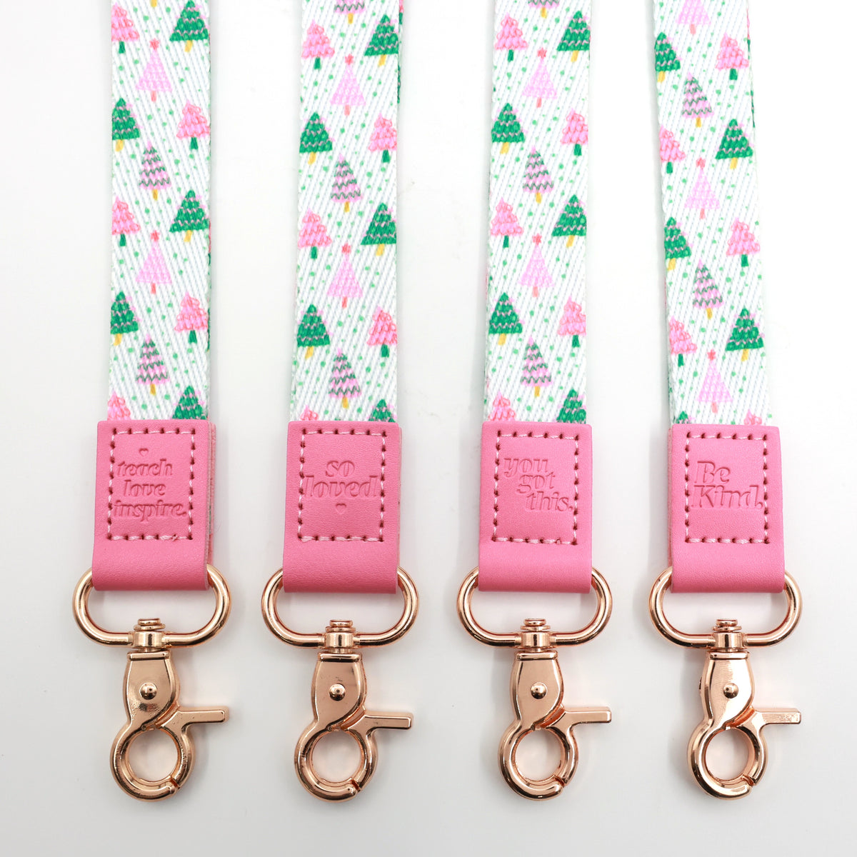 Christmas Delight lanyards with colourful Christmas trees, pink message tabs and gold-tone clasps, showing all four messages.