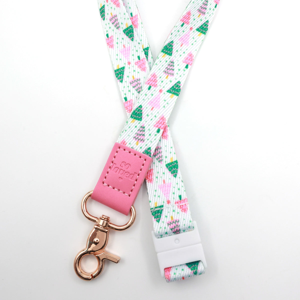 Christmas Delight lanyard with colourful Christmas trees, a pink So Loved tab, gold-tone clasp and white breakaway fastening.