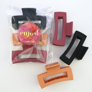 Hair accessories. 3 pack of hair claw clips in matte black, orange and raspberry. 