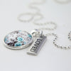 Teal floral print pendant necklace in bright silver with loved charm.