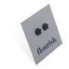 Flower Power studs in black stainless steel on a foil flourish card.