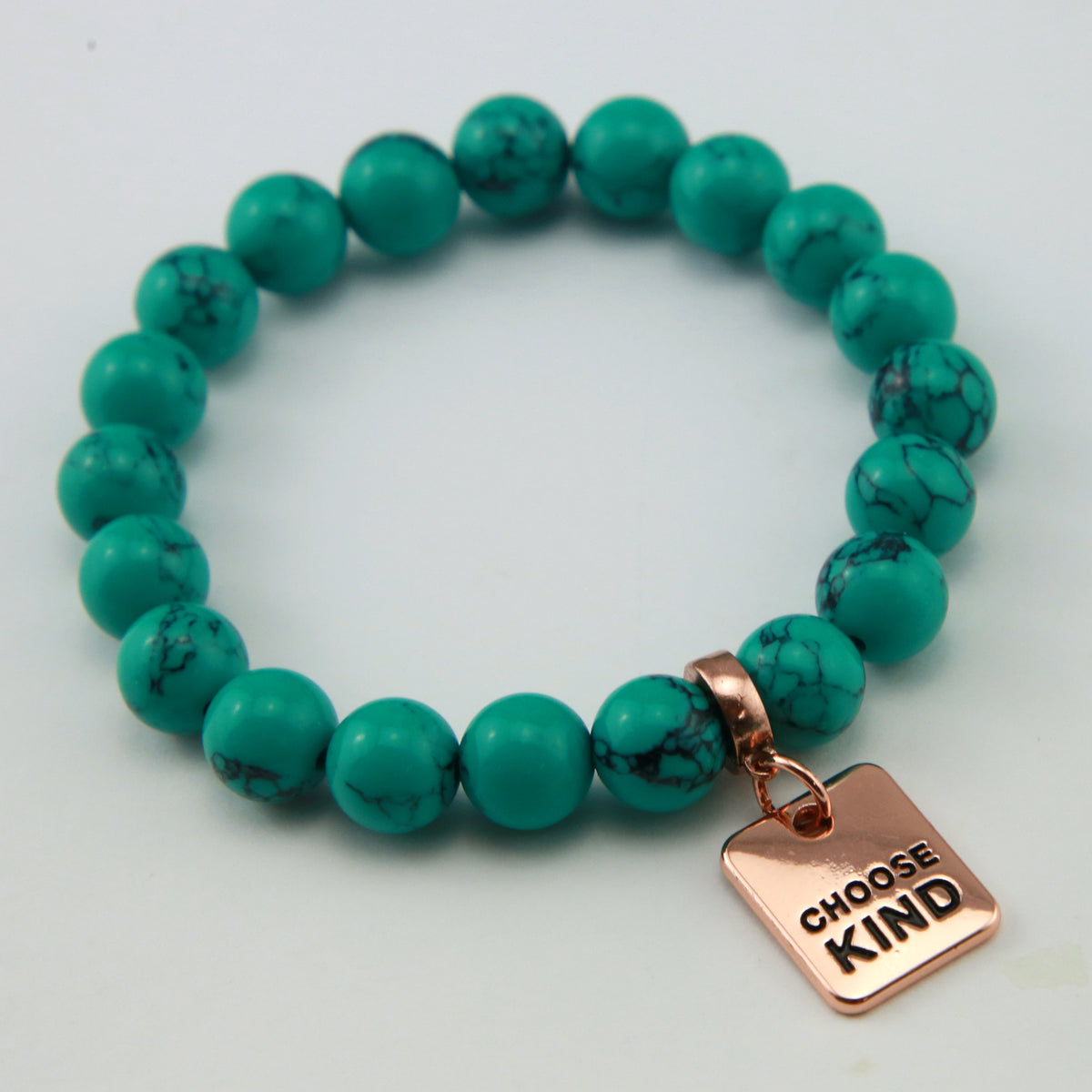 Teal coloured stone bracelet with word charm and rose gold clip. 