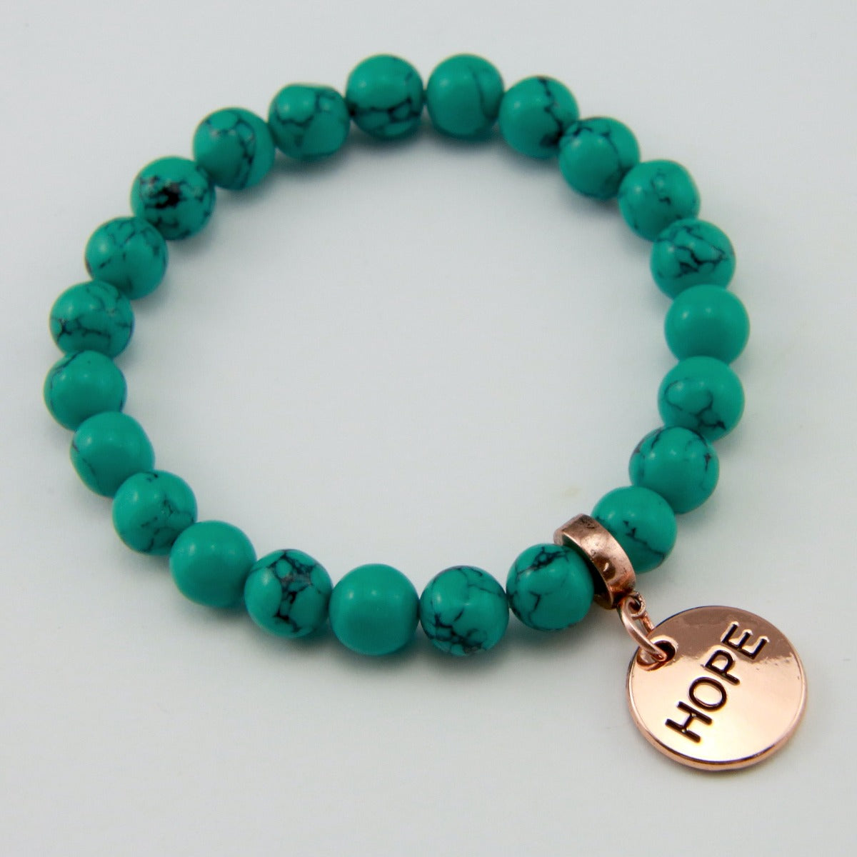 Teal coloured stone bead bracelet with rose gold charm