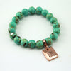 Teal coloured stone bead bracelet with rose gold word charm.