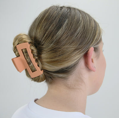 Girl wearing hair claw clip to demonstrate size.