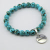 Teal coloured stone bracelet with word charm and silver clip.