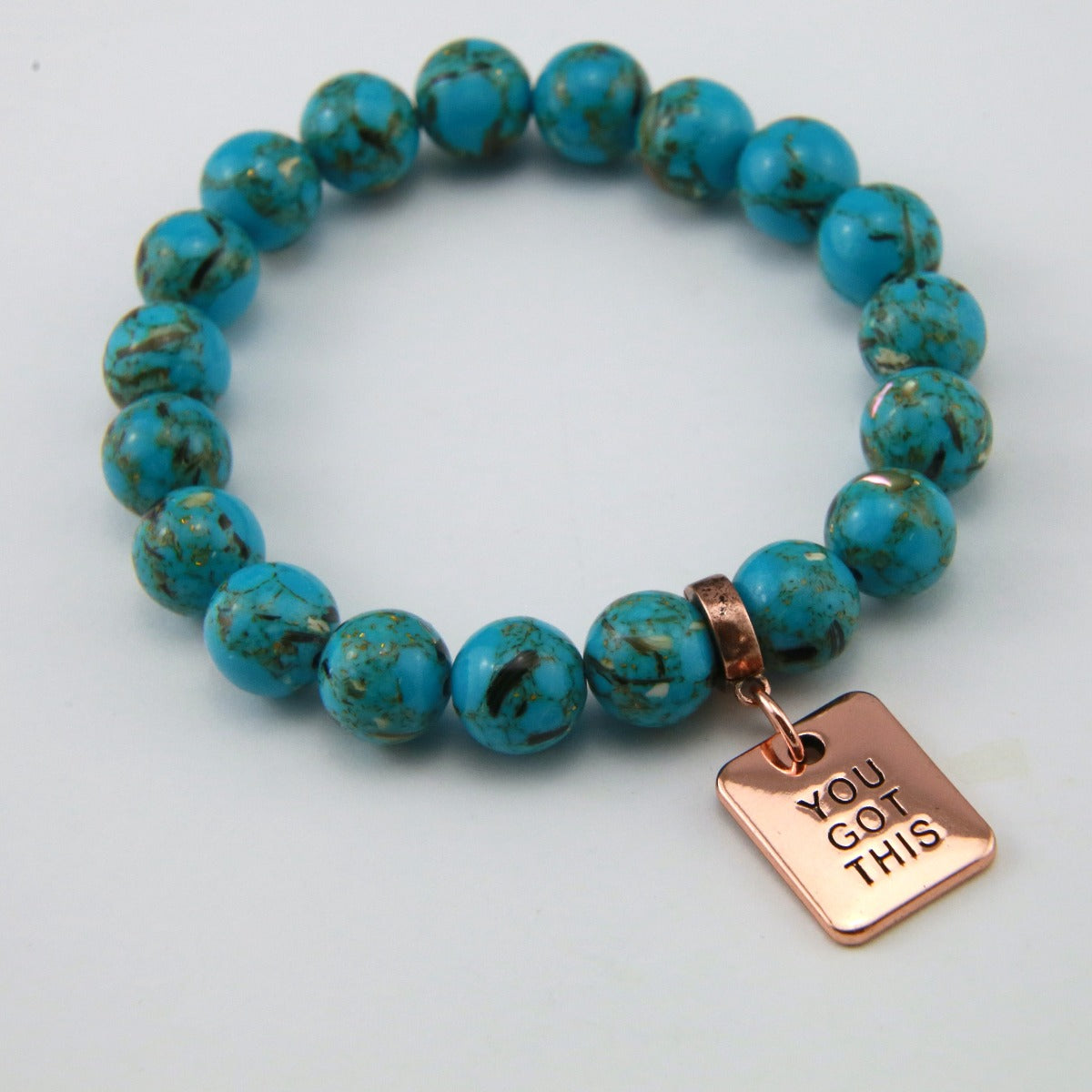 Teal coloured stone bracelet with word charm and rose gold clip. 