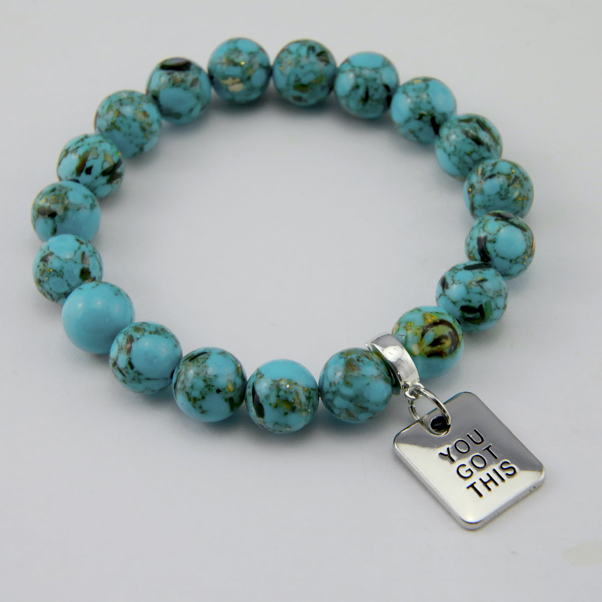 Teal coloured stone bracelet with word charm and silve r clip. 