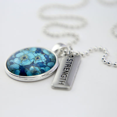 Teal floral print pendant necklace in bright silver with strength charm.