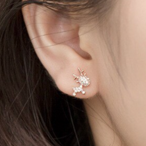 Tiny reindeer earring in ear