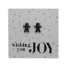 Black stainless steel gingerbread cookies on foil wishing you joy card.